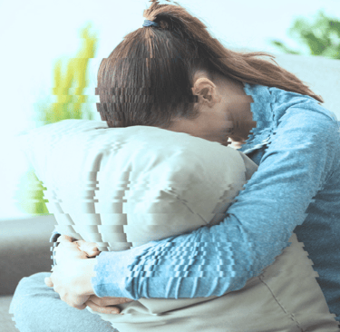 a woman sitting on a couch with a pillow