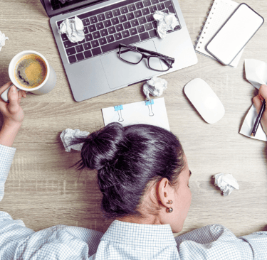 a woman sitting at a desk with a cup of coffee