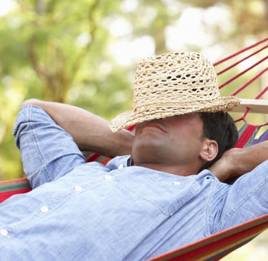 a man in a straw hat is laying in a hammock