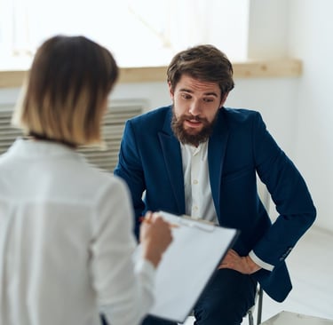 a man and woman in business attire sitting in a meeting room