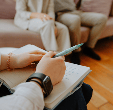 a person sitting on a couch with a pen and a pen