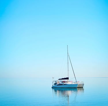 a sailboat in the water with a blue sky
