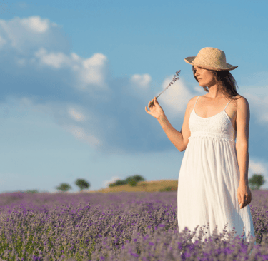 a woman in a white dress and straw hat holding a wand