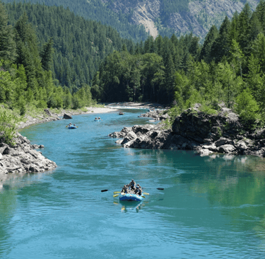 a group of people rafting down a river