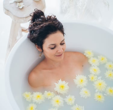 a woman in a bathtub with flowers in the tub