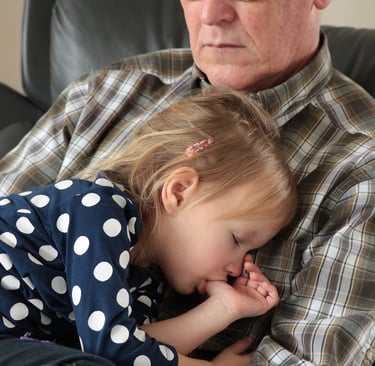 a man and a little girl are sitting on a couch