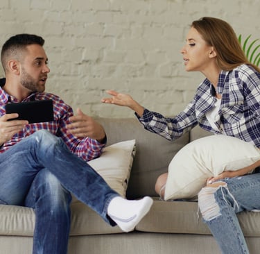 Couple in conflict on sofa, representing the need for marriage counselling