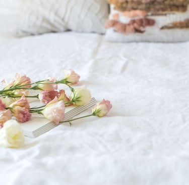 a cake with flowers on a bed in a bedroom