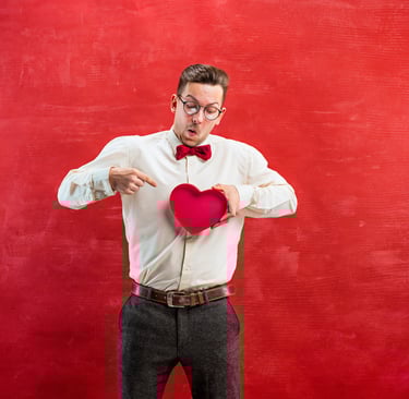Hombre sosteniendo regalo de San Valentín corazón con un fondo rojo