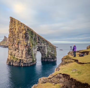 Photographer capturing a shot of Drangarnir in the Faroe Islands