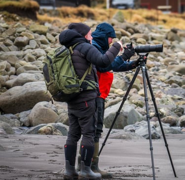 Landscape photographer at work in winter conditions, Faroe Islands