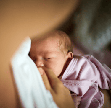 Lisa conducting a follow-up home visit, assessing baby's progress in a comfortable setting