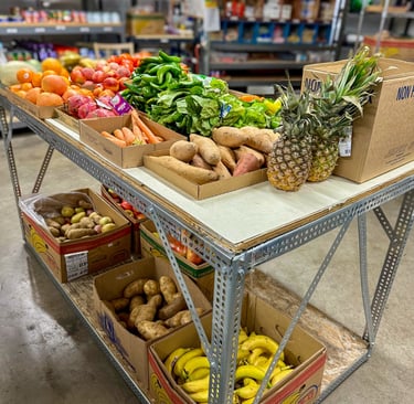 Pantry interior with table of fresh produce and shelves with canned and boxed food