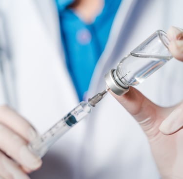 Healthcare professional dispensing medication via needle and syringe.