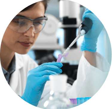 a woman in a lab coat and gloves holding a pipe of liquid