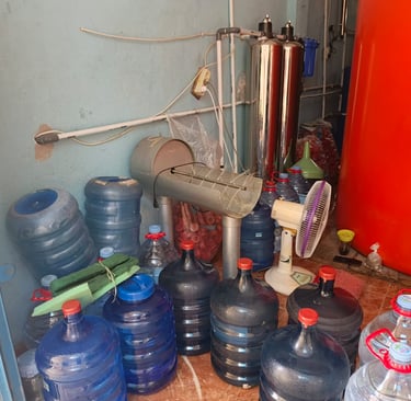 a man standing in front of a bunch of water bottles