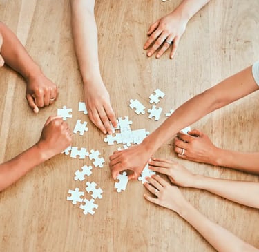 3 people solving a puzzle on a table