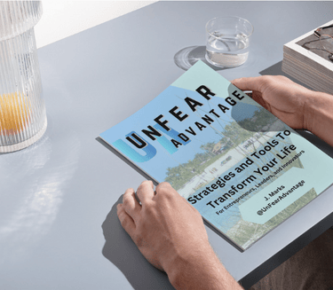a person holding a book in front of a table