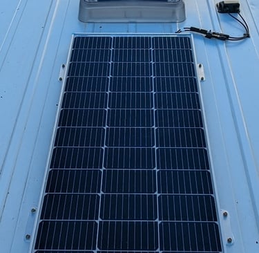 Rigid solar panel mounted to campervan roof using screws