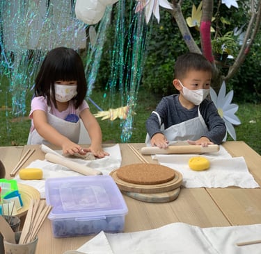 a group of children wearing masks while making pottery