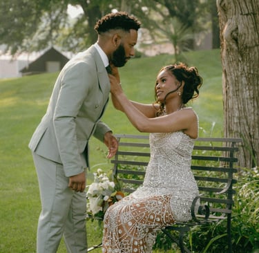 Couple qui sont dans un jardin . La femme remet la cravate de son mari correctement