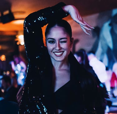 bailarina guiñando un ojo, posando en el restaurante mientras se desarrolla el show dinner