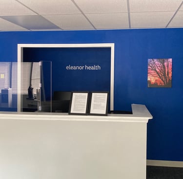 Eleanor Health front desk with tree with sunset wall art