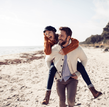 Una pareja feliz corriendo por la playa