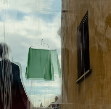 a figure in front of a building and a washing line