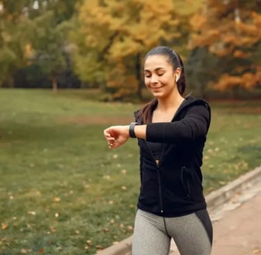 Uma mulher caminhando em um parque pela manhã, usando roupas de ginástica