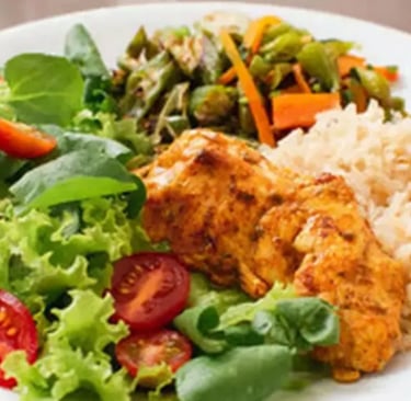 Prato de comida com, frango, arroz e saladas 