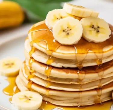 uma pilha de panquecas com bananas e mel