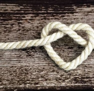 un cœur fait de corde posé sur une planche en bois