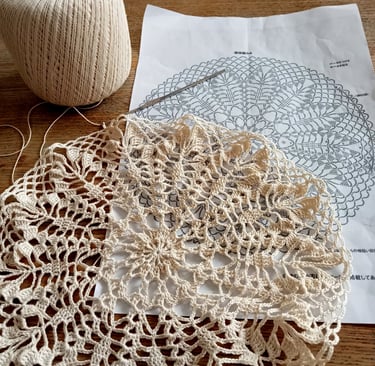 napperon dentelle crochet posé sur un feuille et une table en bois