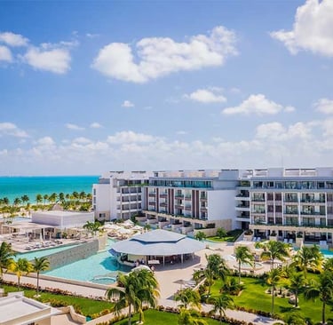 a large hotel with a pool and a view of the ocean
