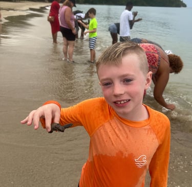 a young boy is holding a fish in his hand