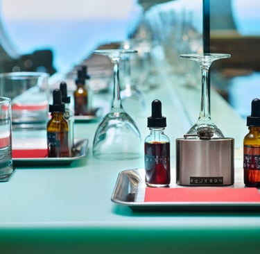 A craft cocktail kit with bourbon bitters and rich syrup bottles on a modern bar counter.