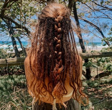 a woman with long hair and a braid braid in her hair and dreadlocks