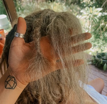 a woman who is getting her dreadlocks brushed out