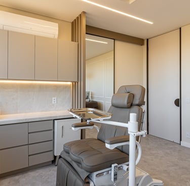 Consultório médico com marcenaria sob medida: armário inferior e superior, mini geladeira e bancada.