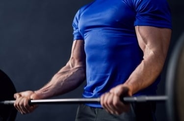 a man in a blue shirt is holding a barbell