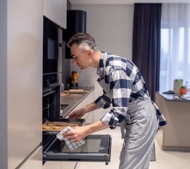 a man placing a baking sheet in the oven