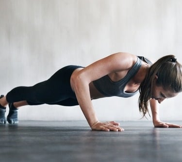 a woman doing push ups on a plank board