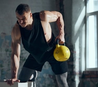 a man in a black tank using a kettlebell