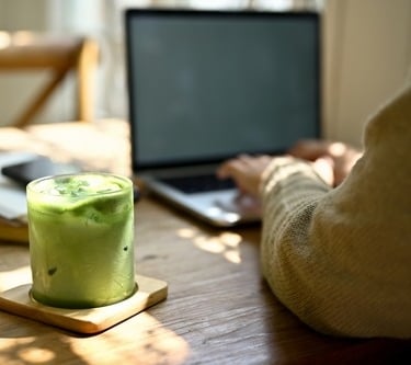 a person sitting at a table with a drink