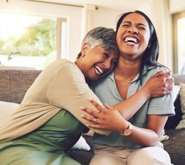 a woman and a woman are smiling and hugging