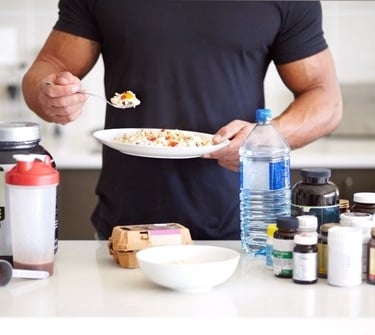 a man holding a plate with food and a fork