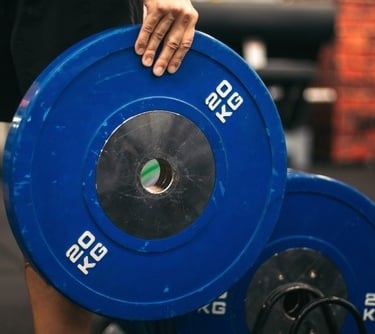 a person holding a blue and white plated weight plate
