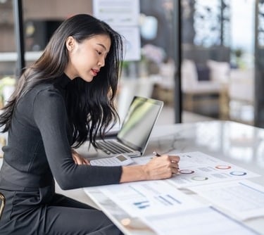 a woman sitting at a table with a laptop 