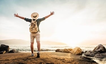 a man standing on a beach with his arms up